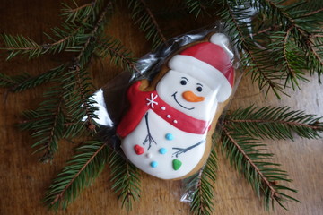 Glazed gingerbread snowman and spruce branch from above