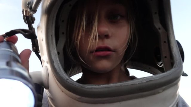 Little Girl with the astronaut helmet in the field
