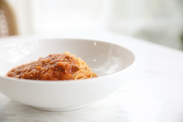 spaghetti Bolognese with minced beef and tomato sauce garnished with parmesan cheese and basil , Italian food