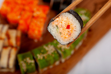 Sushi on a wooden deck with different fillings and seasonings