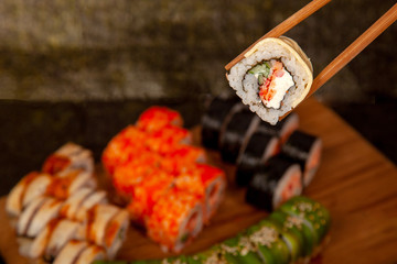 Sushi on a wooden deck with different fillings and seasonings