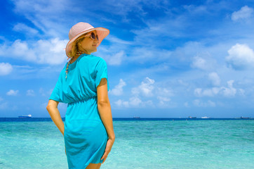 Fototapeta na wymiar woman in fashion beachwear and hat on tropical beach on summer vacation travel.
