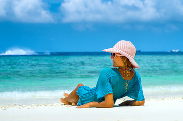 woman in fashion beachwear and hat on tropical beach on summer vacation travel.