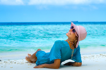 woman in fashion beachwear and hat on tropical beach on summer vacation travel.