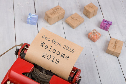 Holidays concept - red typewriter with text "Goodbye 2018 Welcome 2019", gift boxes