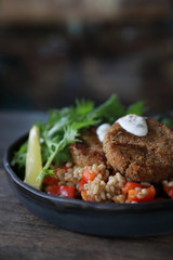 salmon fishcakes with oat and salad on wooden table