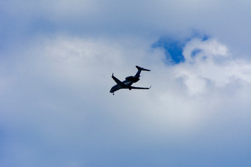 A large passenger airliner is a plane with a big wingspan high in the sky. Transport tourists for exotic holidays against the blue sky and white clouds