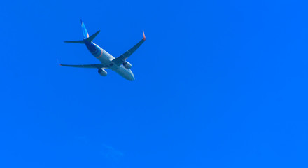 Fototapeta na wymiar A large passenger airliner is a plane with a big wingspan high in the sky. Transport tourists for exotic holidays against the blue sky and white clouds
