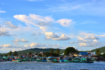 Fishing boats at the harbour in Phu Quoc, Vietnam. Hills and nice clouds in the background.