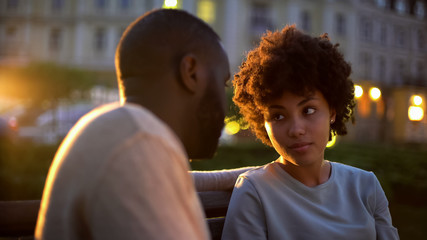 Offended woman looking at boyfriend, outdoor date, misunderstanding, conflict