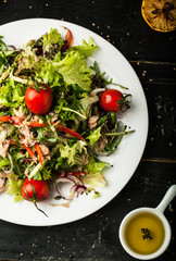 Tasty salad with tuna on dark background