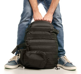 Man legs feet jeans sneakers with backpack on a white background. Isolation