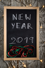 Black chalkboard with the written words NEW YEAR 2019