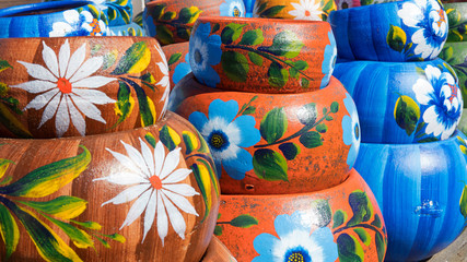 Close up on sets of colorful hand painted Mexican ceramic pots, traditional pottery found at a market stall in Old Town, a state historic park in San Diego, California, USA 