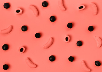 Stylish colorful candy pattern on pastel background. Top view. Flat lay. Backdrop for your design. Color of the year 2019. Living coral.