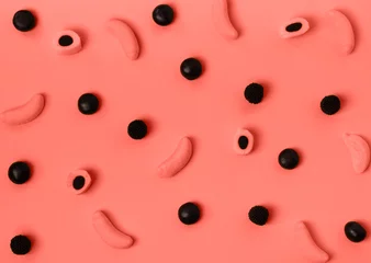 Stilvolles buntes Bonbonmuster auf pastellfarbenem Hintergrund. Ansicht von oben. Flach liegen. Hintergrund für Ihr Design. Farbe des Jahres 2019. Lebende Koralle. © Zaitseva