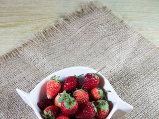 strawberries in a basket on wooden table