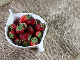 strawberries in a bowl on wooden table