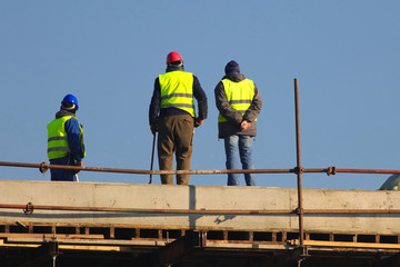 Three workers in safety equipment on the construction site
