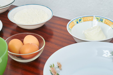 The process of making pie dough by hand. Baking cake in a kitchen dough recipe ingredients eggs, flour, milk, butter, sugar on a table. Sequence, step by step, part of series.