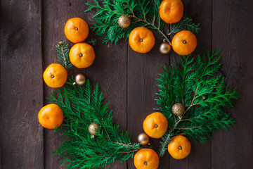 Christmas new year background with tangerines and a wreath of fir branches . winter still. selective focus. copy space