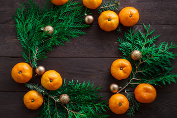 Fototapeta na wymiar Christmas new year background with tangerines and a wreath of fir branches . winter still. selective focus. copy space