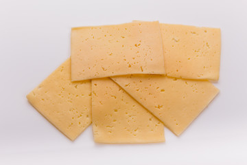Piece and slices of cheese on a white background