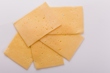 Piece and slices of cheese on a white background