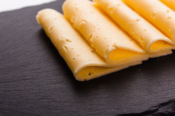 Piece and slices of cheese on a white background