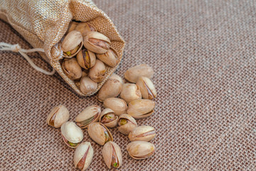 Pistachios spilled from a sack, on sack surface