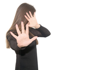 a young woman in black clothes pulled her hands and hid  face. The girl feels fear. Isolated on a white background.