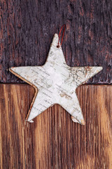 Beautiful star of birch bark on wooden craftsman background (light and dark). Ready for Christmas greeting.