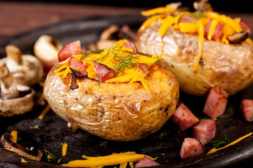Baked stuffed potatoes with bacon, cheddar, mushrooms and dill
