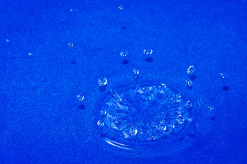 Close up. High speed photography. Splash of water droplets. Blue background.