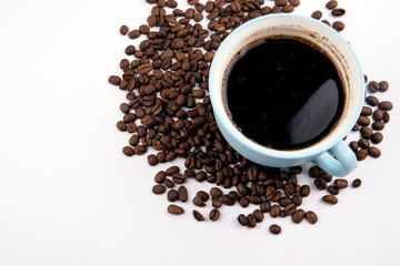 coffee mug with coffee beans on a white table, with copy space
