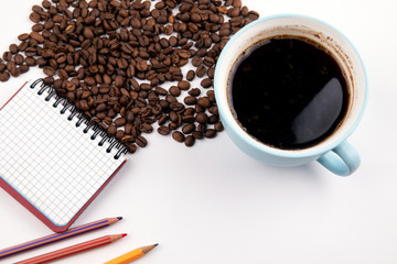coffee mug with coffee beans on a white table, with copy space
