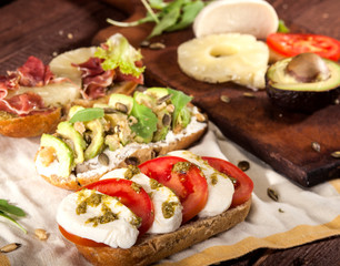 Collection of three different kinds of bruschetta on wooden table.