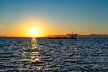 Seascape with beautiful sunset and ships on the horizon.