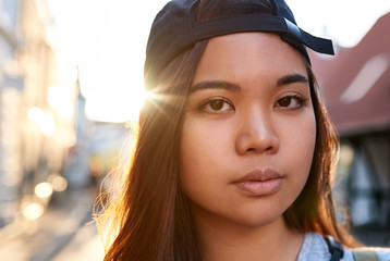 Cool young Asian woman walking along a city street