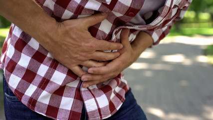 Male feeling abdominal pain outdoors, indigestion discomfort, poisoning, nausea