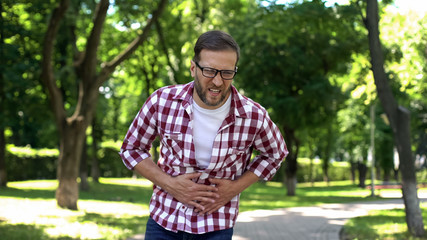 Man feeling stomach pain, gastritis symptom, digestion disease, healthcare