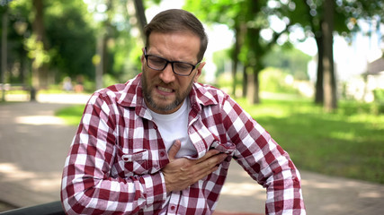 Male feeling chest pain, sitting outdoors, heart arrhythmia, ischemic disease