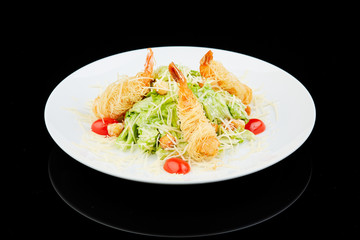 Seafood caesar salad with shrimps, salad leaf, cherry tomato and parmesan cheese.