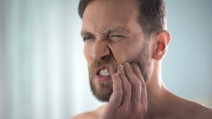 Fototapeta premium Man feeling strong tooth ache, strong dental pain, pulp inflammation, decay