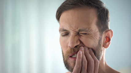 Man checking teeth in front of mirror, dental disease, gum infection, pulpitis