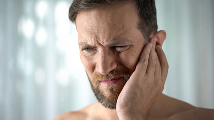 Ill man feeling ear pain, health care, neurological infection, itchiness otitis