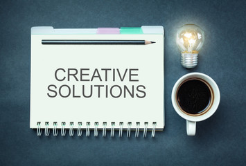 Word Creative Solutions on notepad. Business concept