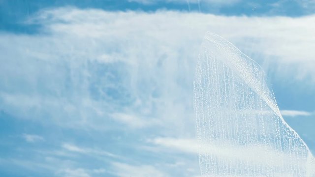 Man washes the wiper with a dirty window from the outside close-up, slow motion