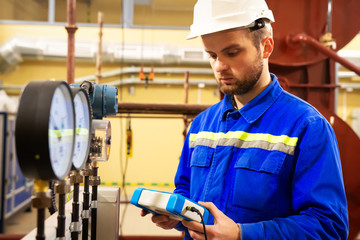 Engineer analyzing measurements with pressure manometers on industrial factory