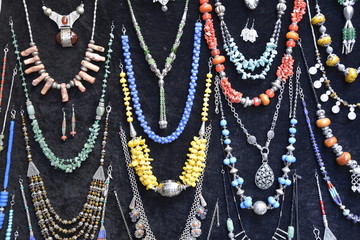 Verschiedene Ketten und Ohrringe mit Glasperlen und traditionellen Mustern der Araber und Berber sind im Souk oder Basar zum Verkauf ausgehängt, Marrakesch, Marokko, Afrika